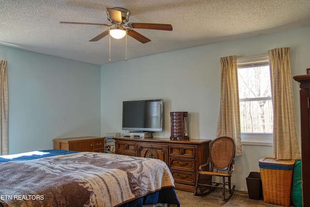 bedroom featuring light carpet, ceiling fan, and a textured ceiling