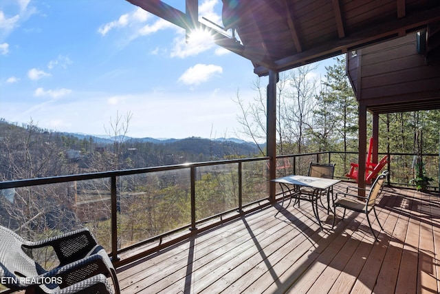 wooden terrace with a wooded view