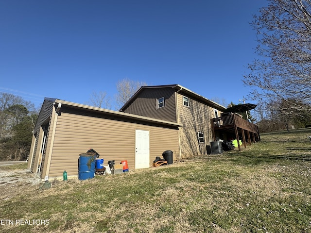 view of side of home featuring central AC, a yard, and a wooden deck