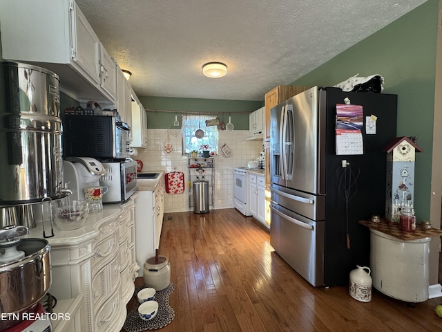 kitchen featuring dark wood-style floors, stainless steel appliances, light countertops, white cabinetry, and a sink