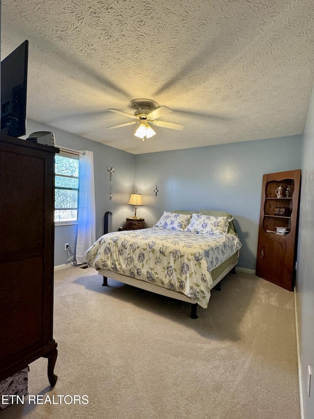 bedroom with baseboards, a ceiling fan, and light colored carpet