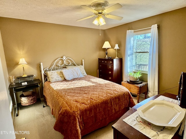 carpeted bedroom with a ceiling fan and a textured ceiling