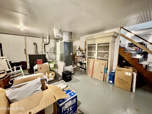 finished basement featuring concrete block wall and stairway