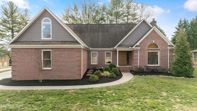 view of front of house featuring brick siding, a chimney, roof with shingles, crawl space, and a front yard