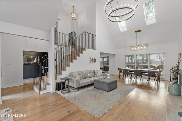 living area with stairs, wood-type flooring, a skylight, and baseboards