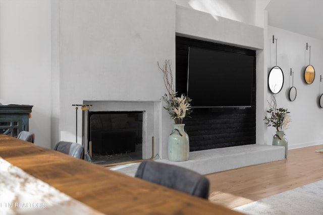 living area with a fireplace and wood finished floors