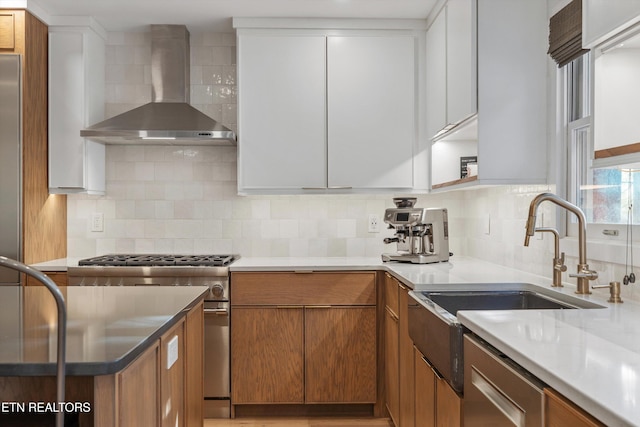 kitchen featuring wall chimney exhaust hood, brown cabinetry, high end stove, and decorative backsplash