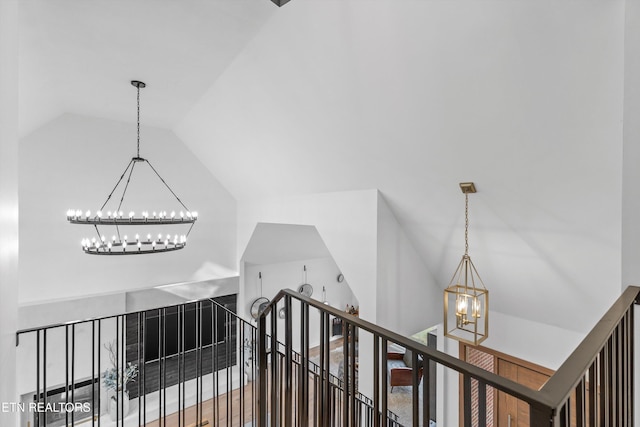 hall featuring lofted ceiling, a chandelier, and an upstairs landing