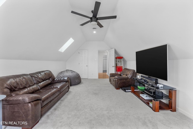 living area featuring lofted ceiling with skylight, carpet, baseboards, and a ceiling fan