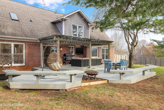 back of house featuring an outdoor living space with a fire pit, fence, a pergola, and brick siding