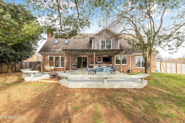 back of house with an outdoor fire pit, a fenced backyard, a patio area, a pergola, and brick siding