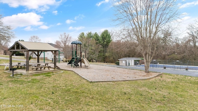 community jungle gym with a gazebo, fence, an outdoor structure, and a yard