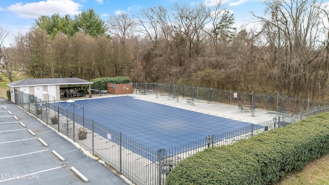 view of pool featuring a patio area, an outdoor structure, and fence