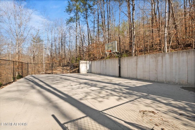 view of patio / terrace with basketball court and fence