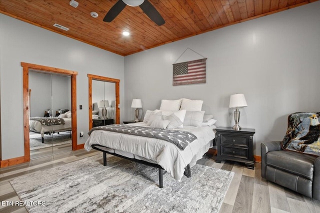 bedroom with wooden ceiling, wood finished floors, visible vents, and baseboards