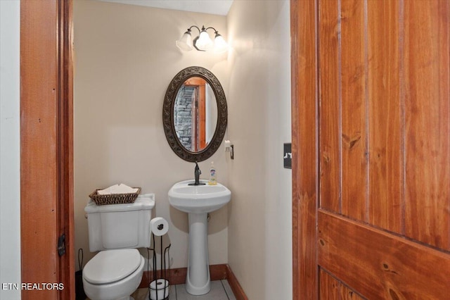 half bath with toilet and baseboards