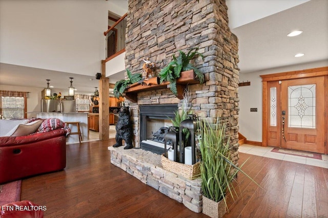 living room with recessed lighting, a fireplace, baseboards, and wood finished floors