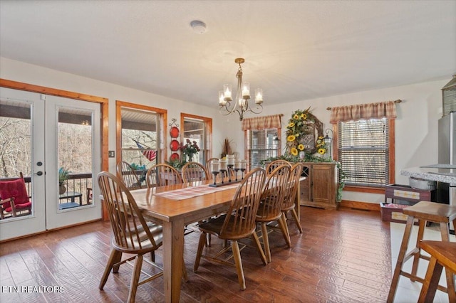 dining space with dark wood-style floors and a notable chandelier