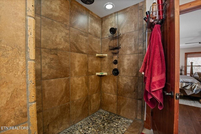 ensuite bathroom featuring wood finished floors, tiled shower, and ensuite bath