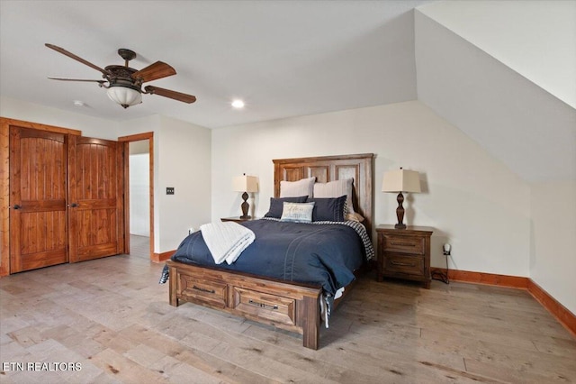 bedroom featuring lofted ceiling, light wood-style flooring, baseboards, and ceiling fan