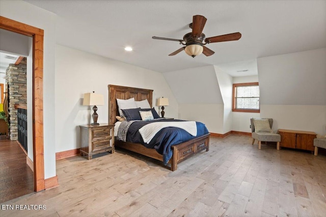 bedroom with lofted ceiling, baseboards, a ceiling fan, and light wood-style floors