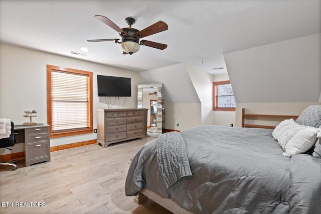 bedroom featuring lofted ceiling, visible vents, ceiling fan, light wood-type flooring, and baseboards