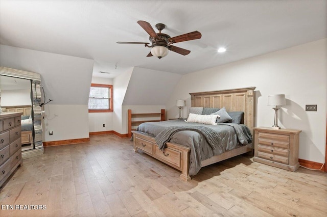 bedroom featuring light wood-style floors, lofted ceiling, ceiling fan, and baseboards