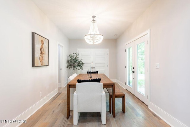 dining room featuring french doors, light wood-type flooring, and baseboards