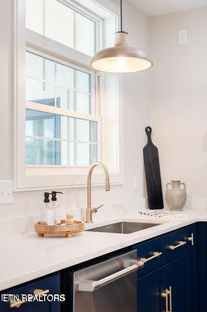 kitchen with hanging light fixtures, stainless steel dishwasher, plenty of natural light, and blue cabinets