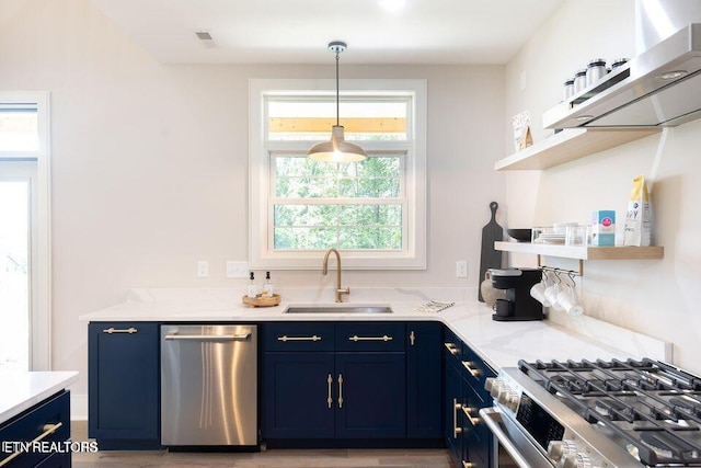 kitchen featuring blue cabinets, light stone countertops, stainless steel appliances, open shelves, and a sink