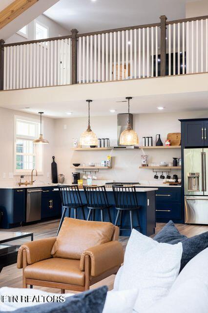 living area with wood finished floors and a towering ceiling