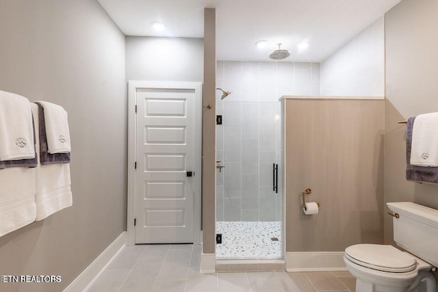 full bathroom with toilet, a shower stall, baseboards, and tile patterned floors