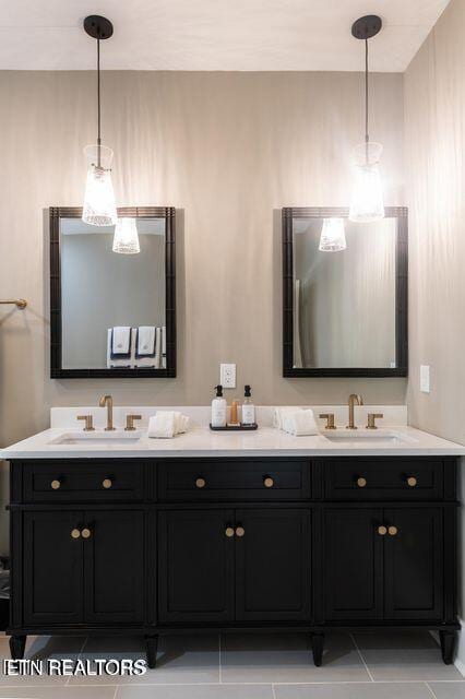 bathroom with tile patterned flooring, a sink, and double vanity