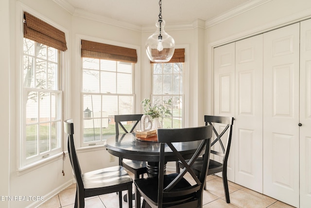 dining room featuring light tile patterned floors, a healthy amount of sunlight, and ornamental molding