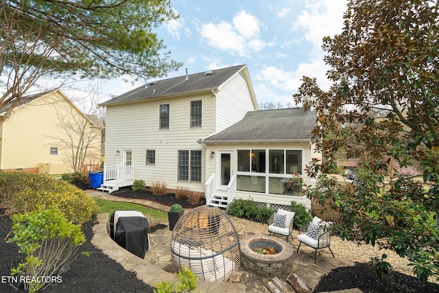 back of house with a patio, roof with shingles, and an outdoor fire pit