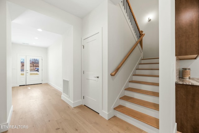 stairway with recessed lighting, visible vents, baseboards, and wood finished floors