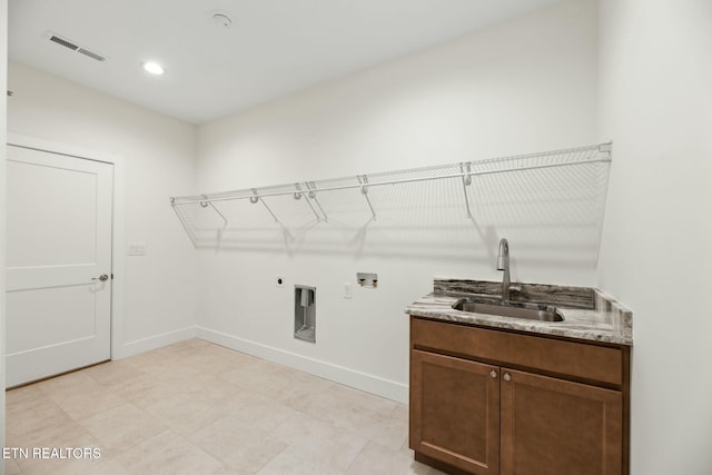 laundry room featuring hookup for an electric dryer, washer hookup, a sink, visible vents, and baseboards