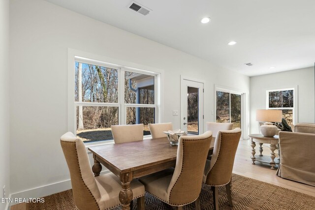 dining space featuring baseboards, wood finished floors, visible vents, and recessed lighting