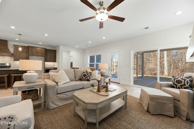 living area featuring recessed lighting, visible vents, and ceiling fan