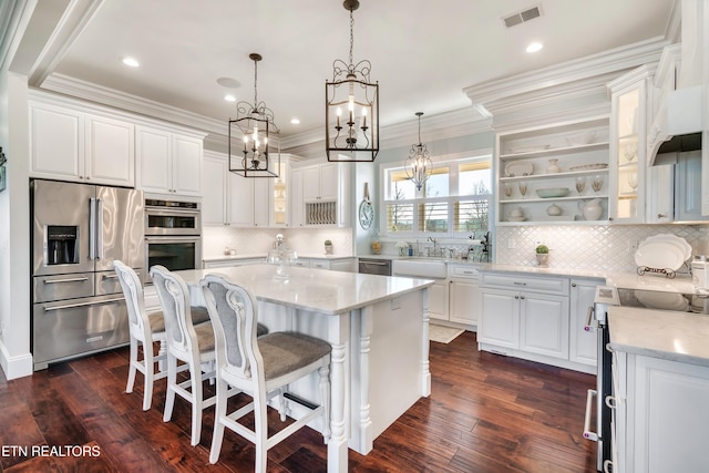 kitchen with white cabinetry, visible vents, a kitchen island, and appliances with stainless steel finishes