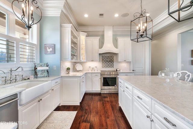 kitchen featuring a notable chandelier, stainless steel appliances, a sink, ornamental molding, and custom exhaust hood