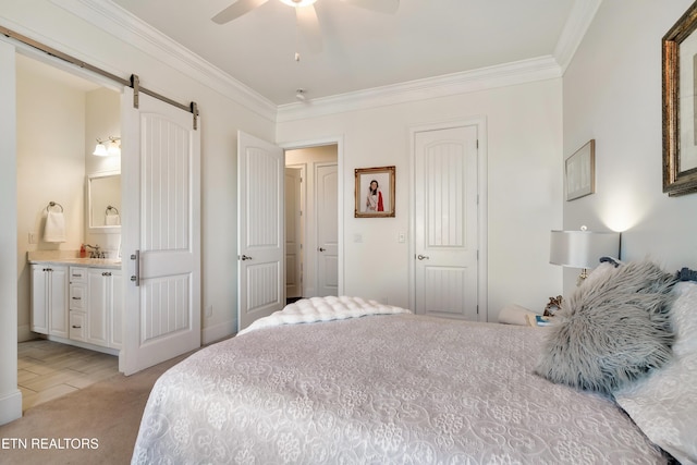 bedroom featuring light carpet, crown molding, ensuite bath, and a barn door