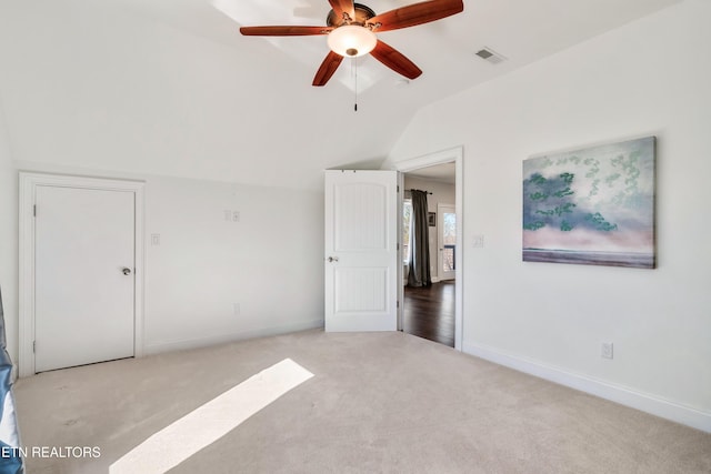 unfurnished bedroom featuring carpet, lofted ceiling, visible vents, ceiling fan, and baseboards