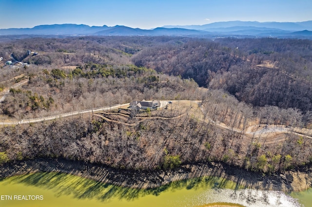 birds eye view of property featuring a mountain view and a view of trees