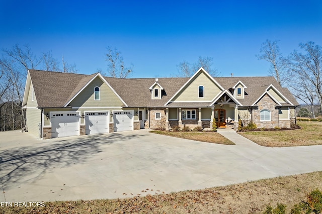 craftsman-style house with driveway, stone siding, and a shingled roof