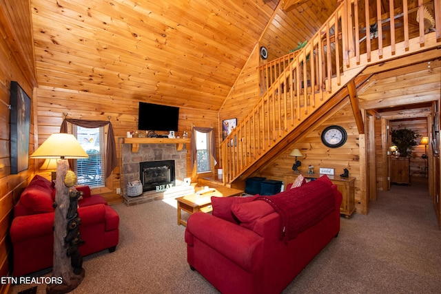 living area with a healthy amount of sunlight, wooden walls, stairway, and carpet flooring