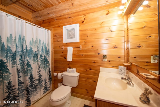 bathroom featuring wooden walls, vanity, toilet, and tile patterned floors