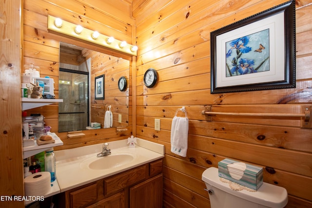 bathroom with a shower with shower door, vanity, toilet, and wooden walls