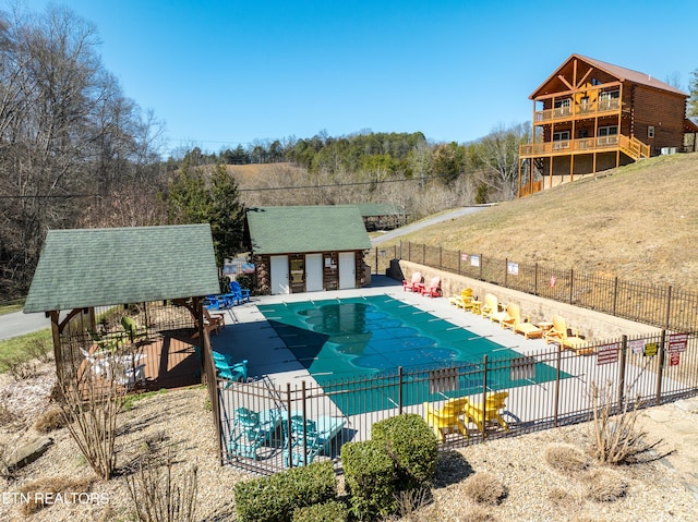 pool with an outbuilding, a patio, a yard, and fence