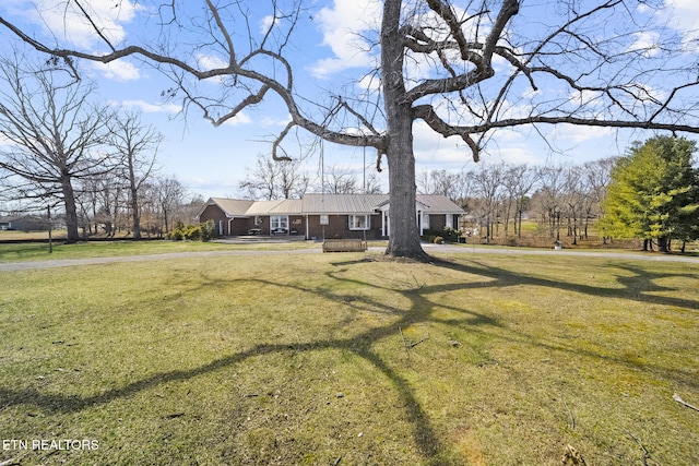 view of front of property with metal roof and a front yard